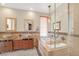 Well-lit bathroom featuring double vanities, a soaking tub, and a glass-enclosed shower at 32 Cerchio Basso, Henderson, NV 89011