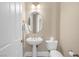 Charming half-bathroom featuring a pedestal sink, oval mirror, and neutral decor at 32 Cerchio Basso, Henderson, NV 89011