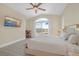 This bedroom has a TV, ceiling fan, and a sliding glass door leading to outdoor desert landscape at 32 Cerchio Basso, Henderson, NV 89011