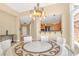 Elegant dining room showcasing a large round table, chandelier, and access to the kitchen at 32 Cerchio Basso, Henderson, NV 89011