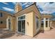 Back exterior view of a home with large windows, doors and a landscaped yard and stone trim at 32 Cerchio Basso, Henderson, NV 89011