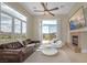 Relaxing living room with fireplace, ceiling fan, and great views from the large windows at 32 Cerchio Basso, Henderson, NV 89011