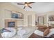 Spacious living room featuring a cozy fireplace, modern seating, and open access to other areas at 32 Cerchio Basso, Henderson, NV 89011