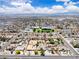 Expansive aerial view of a residential neighborhood with mountain views, and a school in the center at 3845 S Torrey Pines Dr, Las Vegas, NV 89103