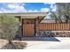 Charming single-story home featuring a wooden fence atop a stone wall and lush landscaping at 3845 S Torrey Pines Dr, Las Vegas, NV 89103
