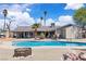 The backyard features a pool, a seating area, mature trees, and blue skies with fluffy clouds at 3845 S Torrey Pines Dr, Las Vegas, NV 89103