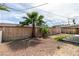 Large backyard with a wooden fence and a variety of plants and gravel at 4393 Swandale Ave, Las Vegas, NV 89121
