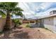 View of the backyard with minimal landscaping, privacy fence, and covered patio adjacent to the house at 4393 Swandale Ave, Las Vegas, NV 89121