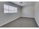 A carpeted bedroom with a window letting in natural light and a ceiling light fixture at 4393 Swandale Ave, Las Vegas, NV 89121