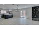 Living area leading into a modern kitchen with white cabinets, black island, and stainless steel appliances at 4393 Swandale Ave, Las Vegas, NV 89121