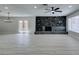 Spacious living room with a stone fireplace, ceiling fan, and light-colored wood-look flooring at 4393 Swandale Ave, Las Vegas, NV 89121