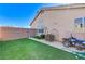 Backyard with patch of artificial grass and motorcycle parked next to home's exterior wall at 444 Flores Cir, Las Vegas, NV 89123