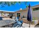 Outdoor patio featuring a dining table set, blue umbrella, and partial view of the home's exterior at 444 Flores Cir, Las Vegas, NV 89123