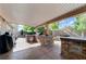 Inviting covered patio with built-in stone grill, bar area, and string lights at 444 Flores Cir, Las Vegas, NV 89123