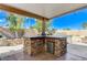 Beautiful backyard patio area with built-in stone barbecue and mini-fridge at 444 Flores Cir, Las Vegas, NV 89123