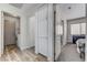 Hallway features light colored wood floors, a gray carpet, and doorways to laundry and bedroom at 444 Flores Cir, Las Vegas, NV 89123
