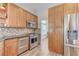 Updated kitchen featuring stainless steel refrigerator, wood cabinets, and tiled backsplash at 444 Flores Cir, Las Vegas, NV 89123