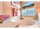 Close up of large garden tub with neutral tile and window at 4471 Borrego Springs Way, Las Vegas, NV 89129