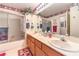 Bathroom featuring double sinks, floral wallpaper border and a shower with sliding glass doors at 4471 Borrego Springs Way, Las Vegas, NV 89129