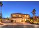 Two-story home with a three-car garage, mature palm trees, and a charming front porch with stone accents at 4471 Borrego Springs Way, Las Vegas, NV 89129