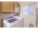 Functional laundry room featuring modern washer and dryer units next to shuttered window at 4471 Borrego Springs Way, Las Vegas, NV 89129