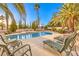 Relaxing pool area surrounded by lush palm trees and comfortable lounge seating at 4471 Borrego Springs Way, Las Vegas, NV 89129