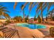 Enjoy a private backyard oasis featuring a sparkling pool and lush landscaping with mature palm trees at 4471 Borrego Springs Way, Las Vegas, NV 89129