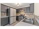 Bright kitchen with dark cabinets, stainless steel appliances, grey countertops and stylish backsplash at 4846 Lone Grove Dr, Las Vegas, NV 89139