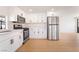 Modern kitchen boasts stainless steel appliances, white cabinetry, and light wood flooring at 4848 Fuentes Cir, Las Vegas, NV 89121