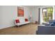 Open living room featuring wood floors, futon with red pillows and balcony access at 4980 Indian River Dr # 447, Las Vegas, NV 89103