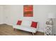 Bright living room with white futon, wood floors, and minimalist decor at 4980 Indian River Dr # 447, Las Vegas, NV 89103