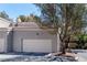 View of the two-car garage with a white door and neutral stucco exterior at 5250 S Rainbow Blvd # 1029, Las Vegas, NV 89118