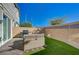 Backyard featuring a patio set, artificial grass, a grill, and a sturdy brick wall at 5269 Silver Branch Ave, Las Vegas, NV 89118