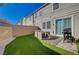 Backyard featuring artificial grass, a seating area, a barbecue and views of a two-story home at 5269 Silver Branch Ave, Las Vegas, NV 89118