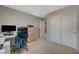 Carpeted bedroom with a desk area, including a monitor, sliding closet door and a door to the next room at 5269 Silver Branch Ave, Las Vegas, NV 89118