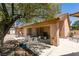 Backyard with covered patio seating area, desert landscaping, and shade tree at 5405 Lucky Clover St, Las Vegas, NV 89149