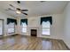 Living room with ceiling fan, wood floors, fireplace, and natural light at 5405 Lucky Clover St, Las Vegas, NV 89149
