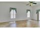 Living room with high ceiling, wood-look flooring, two windows and sliding glass door at 5405 Lucky Clover St, Las Vegas, NV 89149