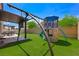 Spacious backyard featuring a play structure, swing set, and artificial grass at 5631 Hill Cliff Ct, North Las Vegas, NV 89031