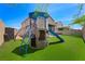 Backyard featuring a modern play structure with a slide and artificial grass at 5631 Hill Cliff Ct, North Las Vegas, NV 89031