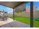 Inviting backyard featuring an outdoor kitchen, covered patio, artificial grass, and privacy wall at 5631 Hill Cliff Ct, North Las Vegas, NV 89031