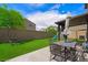 Cozy backyard features artificial grass, a patio set, and a comfortable swing at 5631 Hill Cliff Ct, North Las Vegas, NV 89031
