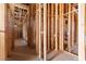 An unfinished hallway exhibits wood framing and essential wiring, revealing construction progress at 5855 St Ebbes Ct, Las Vegas, NV 89131