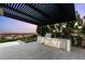 Covered outdoor kitchen and dining area with a built-in grill, perfect for entertaining at 6194 Stone Rise St, Las Vegas, NV 89135