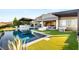 Backyard featuring a sparkling pool, lush lawn, and a built-in outdoor kitchen at 6194 Stone Rise St, Las Vegas, NV 89135