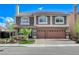 Charming two-story home featuring a tile roof, brick accents, and a well-manicured lawn at 6205 Windy Oaks Ct, Las Vegas, NV 89139