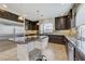 Spacious kitchen features dark wood cabinets, stainless appliances, granite countertops and a center island at 6205 Windy Oaks Ct, Las Vegas, NV 89139