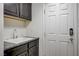 Convenient laundry area with sink, granite countertop, and ample cabinet space at 6205 Windy Oaks Ct, Las Vegas, NV 89139