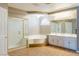 Bright bathroom boasts double sinks, a soaking tub, a stand alone glass shower and stylish gold hardware at 6251 Tuckaway Cove Ave, Las Vegas, NV 89139