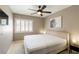 Comfortable bedroom featuring a window with shutters, a ceiling fan, and neutral decor, offering a relaxing retreat at 6251 Tuckaway Cove Ave, Las Vegas, NV 89139